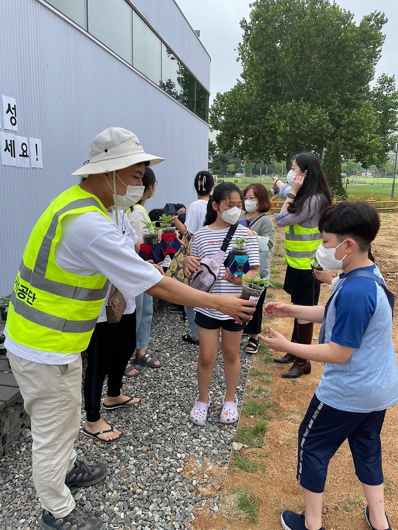 인천시설공단이 부평 캠프마켓을 찾은 시민들에게 폐일회용컵을 재활용한 백일홍 화분을 배부하고 있다. 사진