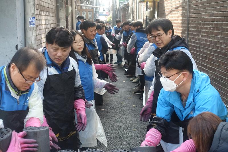 연탄을 나르고 있는 인천시설공단 임직원과 트레이스 청소년봉사단.JPG 이미지